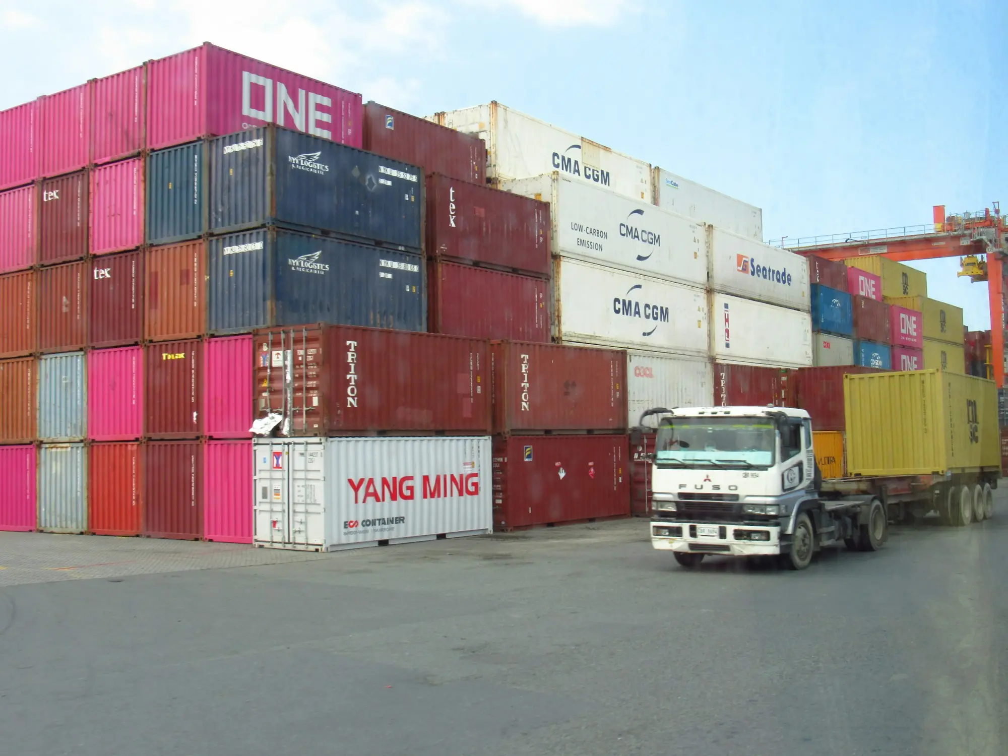 Truck moving past stacked shipping containers